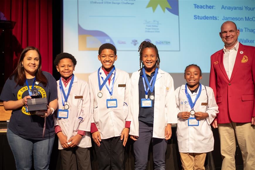 Antonelli poses with the Elementary Expo Winners, the "Monstera Plant" Team from W.H. Owen Elementary School.